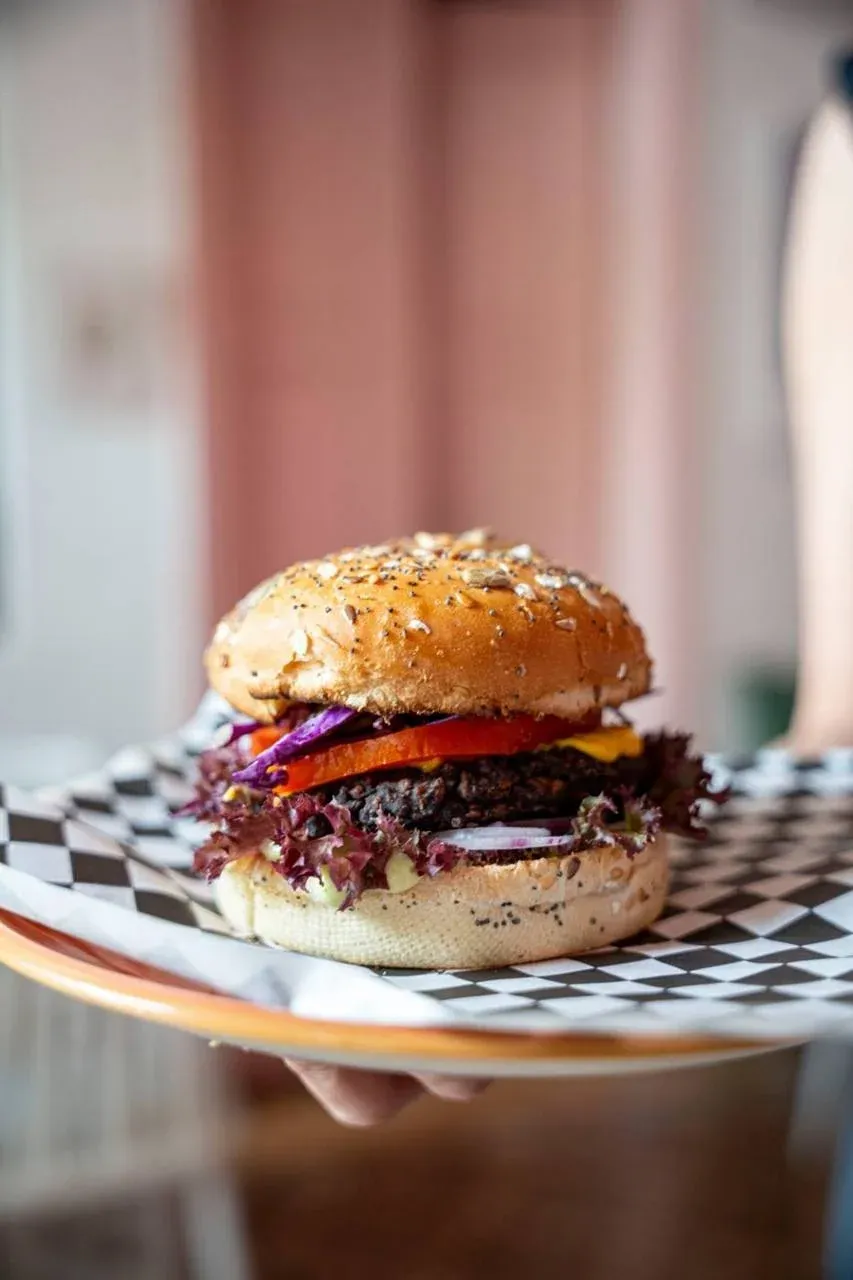 Veggie burger on checkered paper held on a plate